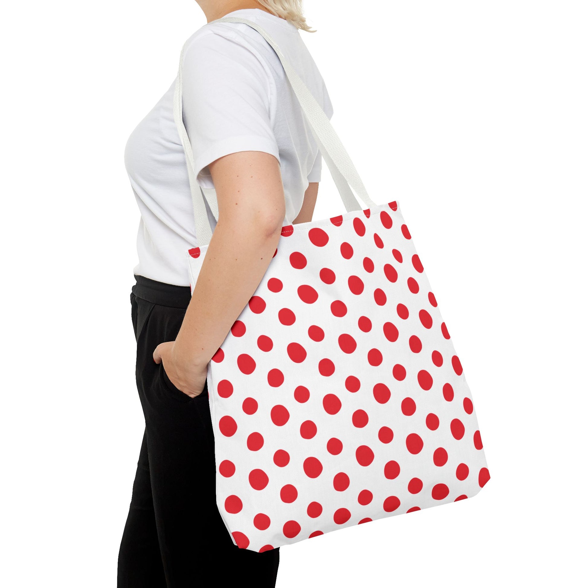 A woman holds the Red Polka Dots Tote Bag, showcasing its playful and vibrant design. The bag, perfect for any occasion, embodies FireBrook Designs' commitment to stylish and joyful living essentials.
