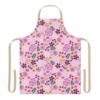 Floral Apron from FireBrook Designs: A full-coverage apron featuring a pink background with vibrant floral patterns. It includes tan/beige neck and waist ties, offering comfort and style for various activities.