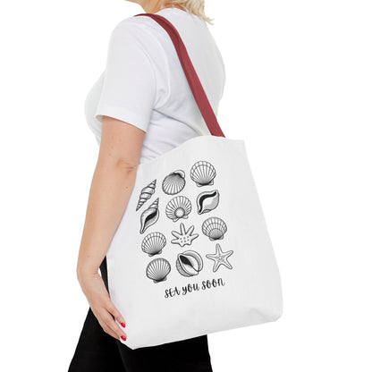 Sea Shells Tote Bag showcasing a nautical-themed design, ideal for beach trips. Made from durable polyester with reinforced stitching and boxed corners, it offers ample space for essentials, embodying FireBrook Essentials' joyful, practical style.