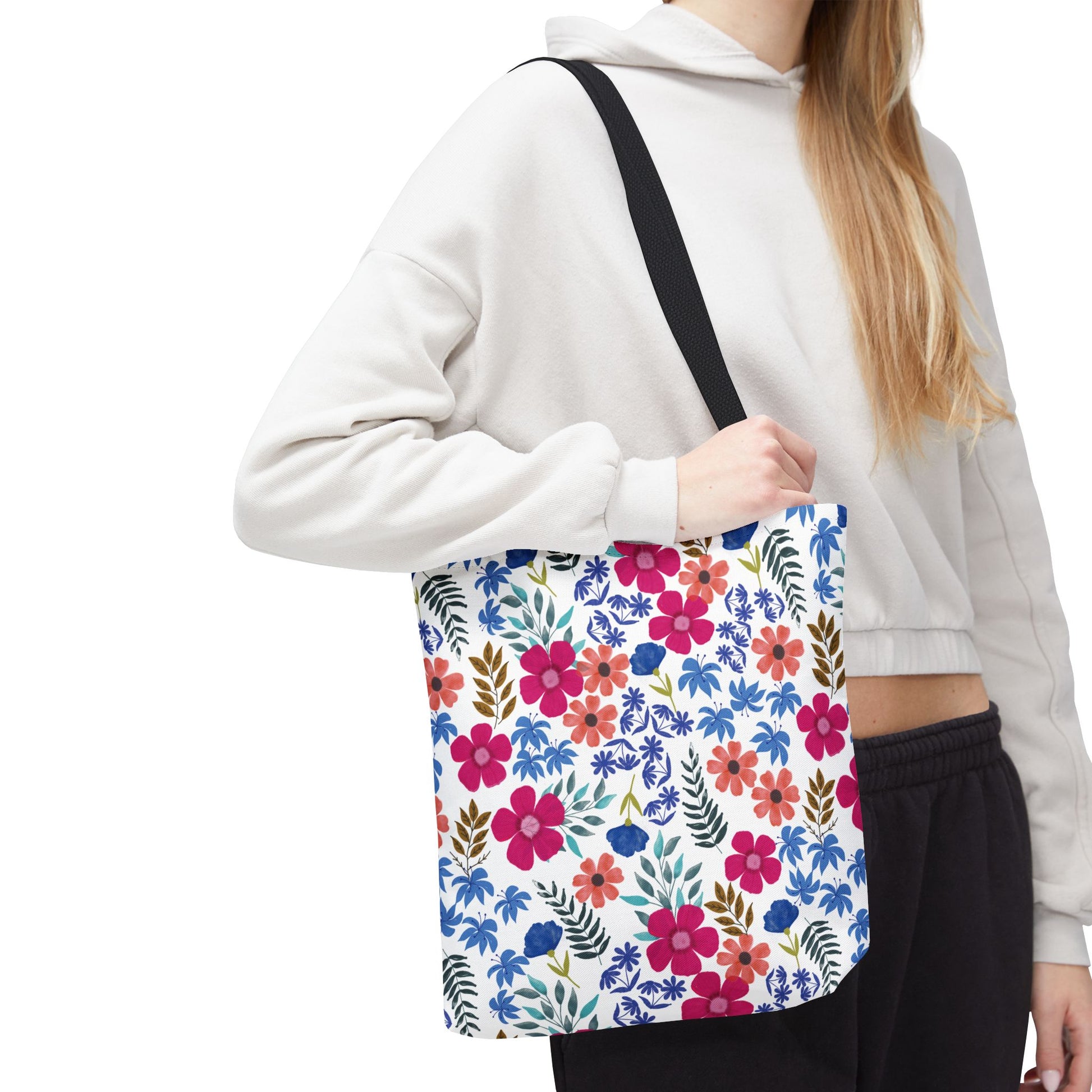 Floral Tote Bag over shoulder, showcasing vibrant pink, red, and blue blooms with green leaves, ideal for cheerful summer outings. Durable polyester construction with reinforced handles, perfect for joyful, stylish use.