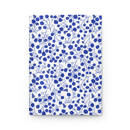 HARDCOVER JOURNAL, MATTE, RULED, 5X7, SEWN BIND, CLEAN-TEAR PAGES – INDIGO PETALS features a striking cobalt-blue floral pattern on a white cover, offering a vibrant and durable writing companion.