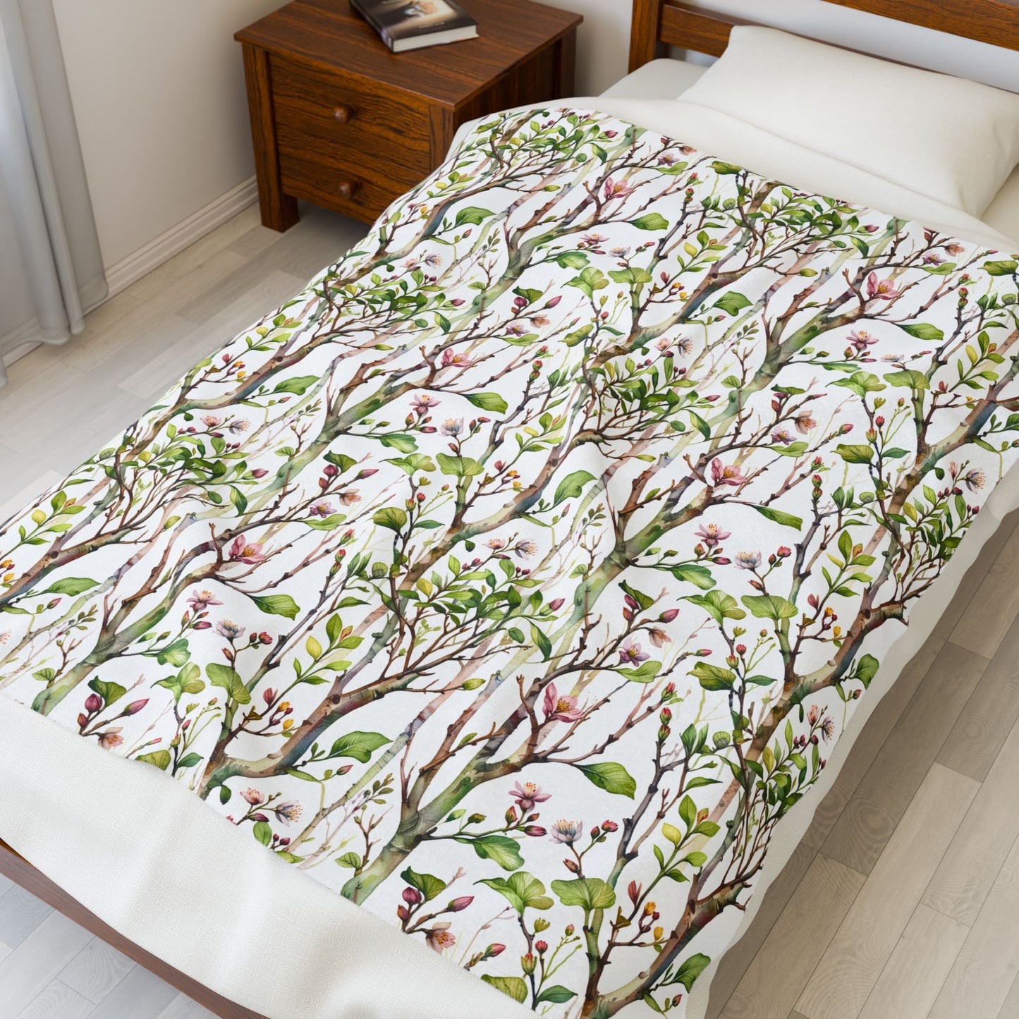 Plush Blanket - Blooming Forest Floor Design on a bed with a nightstand, showcasing budding trees and flowers, ideal for nature lovers and cozy home environments.
