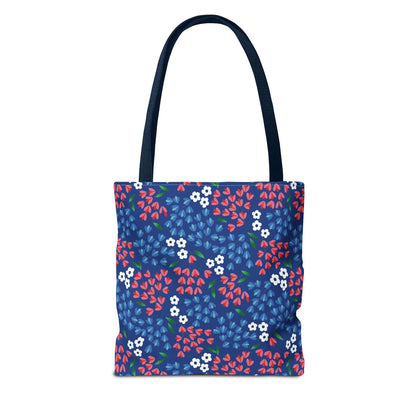 Berry Blue Festival Tote Bag featuring a deep navy blue background with red and lighter-blue leaf shapes, tiny white flowers, and matching navy straps, ideal for vibrant summer outings.