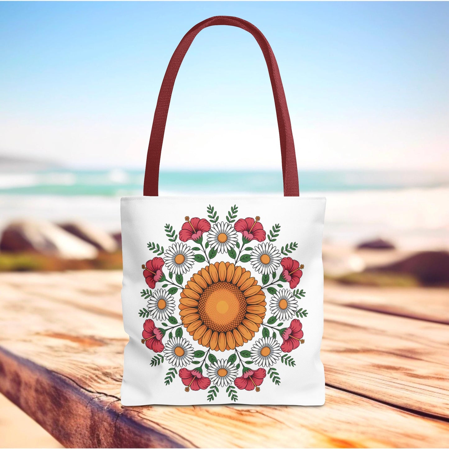 Mandala Sunflowers & Daisies Tote Bag features a vibrant mandala-style floral design, perfect for summer outings. The white canvas bag with burgundy handles embodies boho-chic style and practicality.