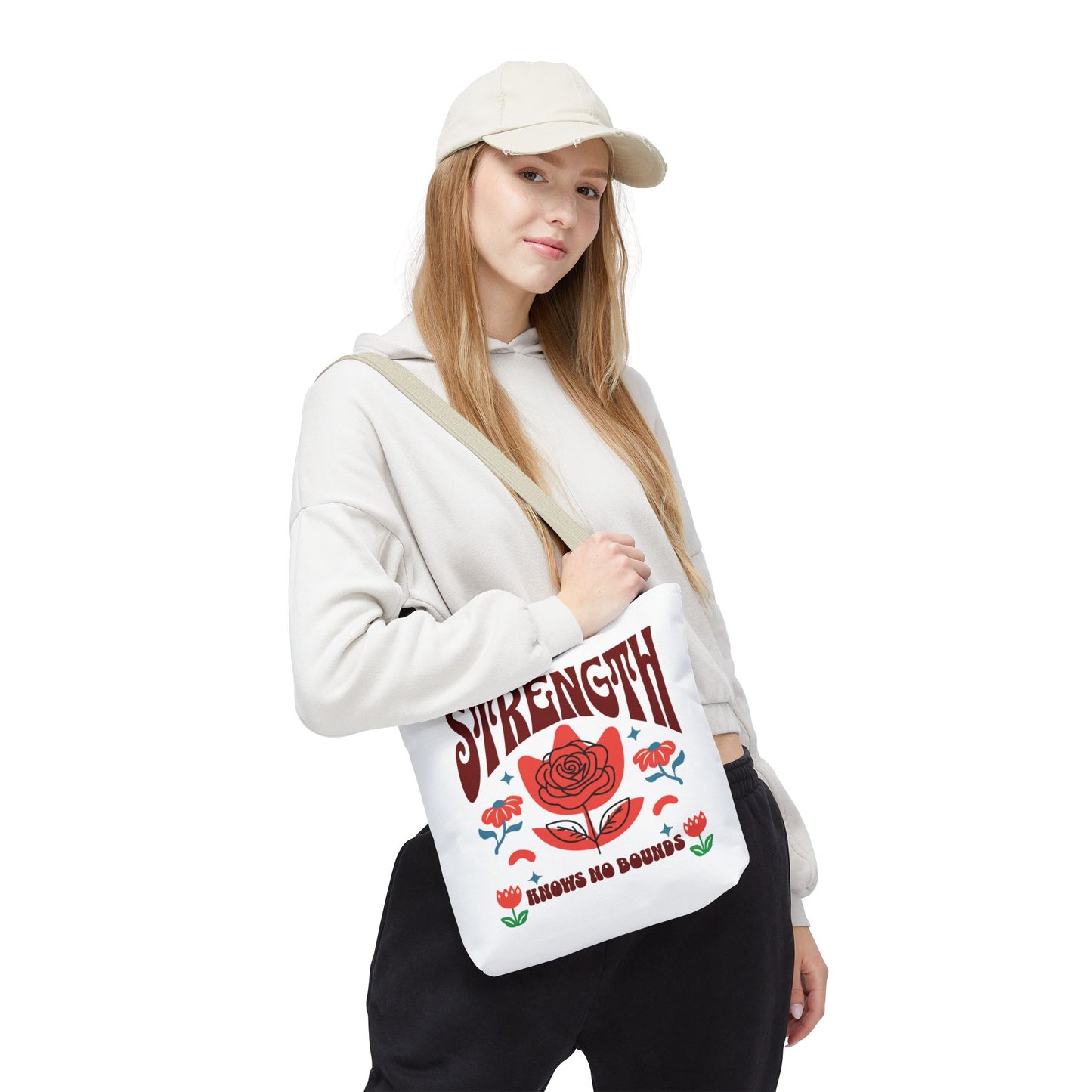 Woman holding the Strength Knows No Bounds Tote Bag, showcasing its spacious design and motivational quote, ideal for everyday use.