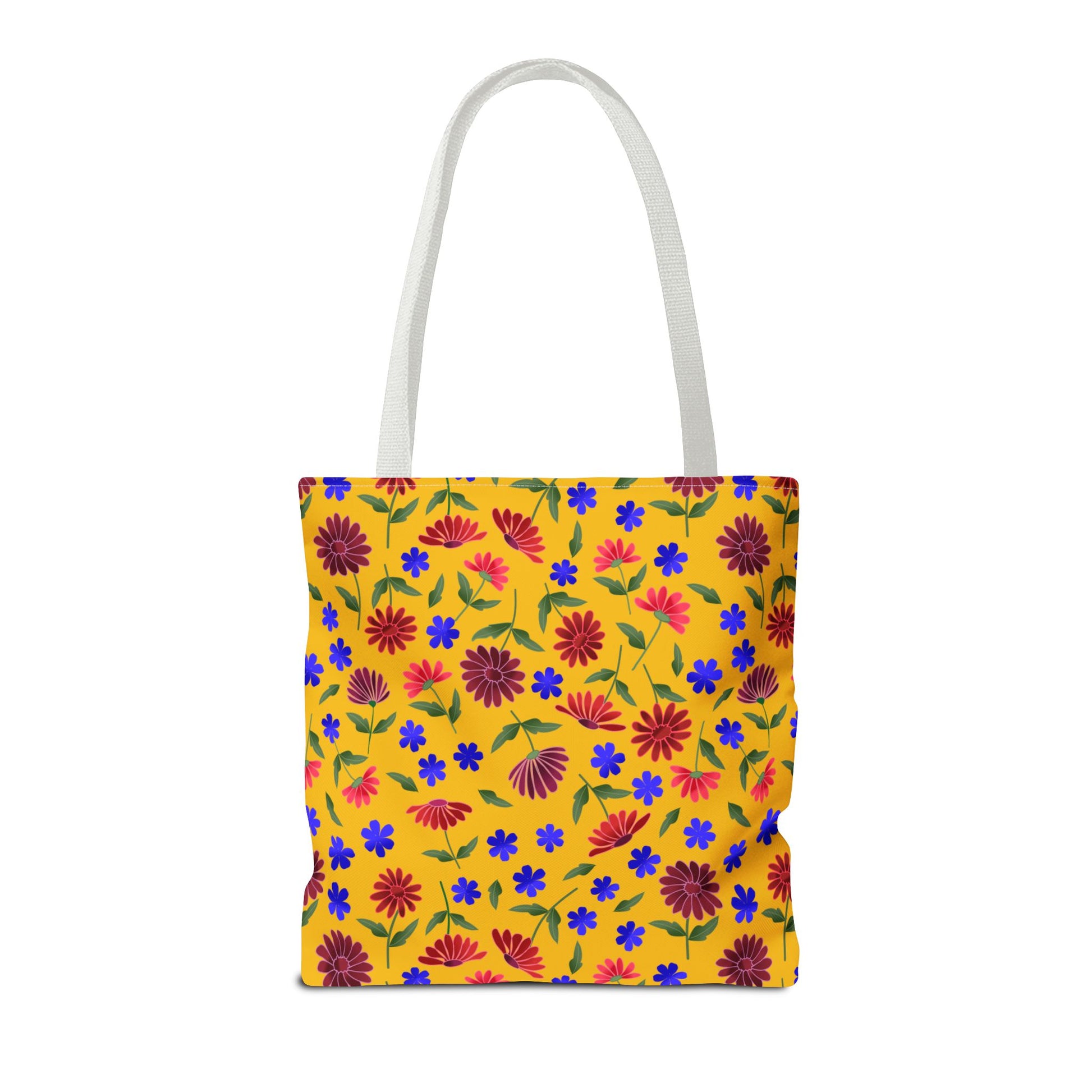 Golden Wildflower Tote Bag with vibrant floral print on mustard-yellow. Features red and maroon daisies, blue blossoms, and green leaves, complemented by durable white straps and boxed corners. Perfect for stylish errands.