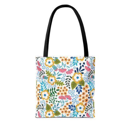 Floral Tote Bag with black straps, featuring a vibrant floral pattern in yellow, pink, blue, and orange on a white background, embodies FireBrook Designs' cheerful style, perfect for summer outings.