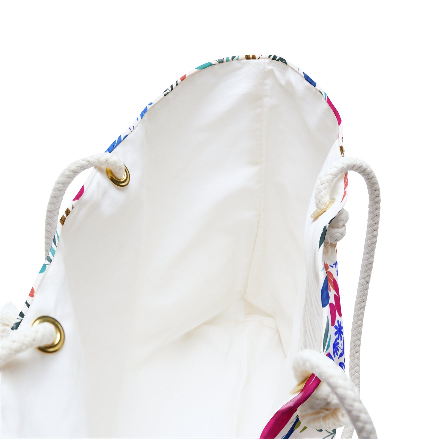 Weekender Bag interior showing unlined white fabric, braided rope handles through brass-tone grommets, and a floral print edge, embodying FireBrook Designs' stylish, uplifting approach to travel essentials.
