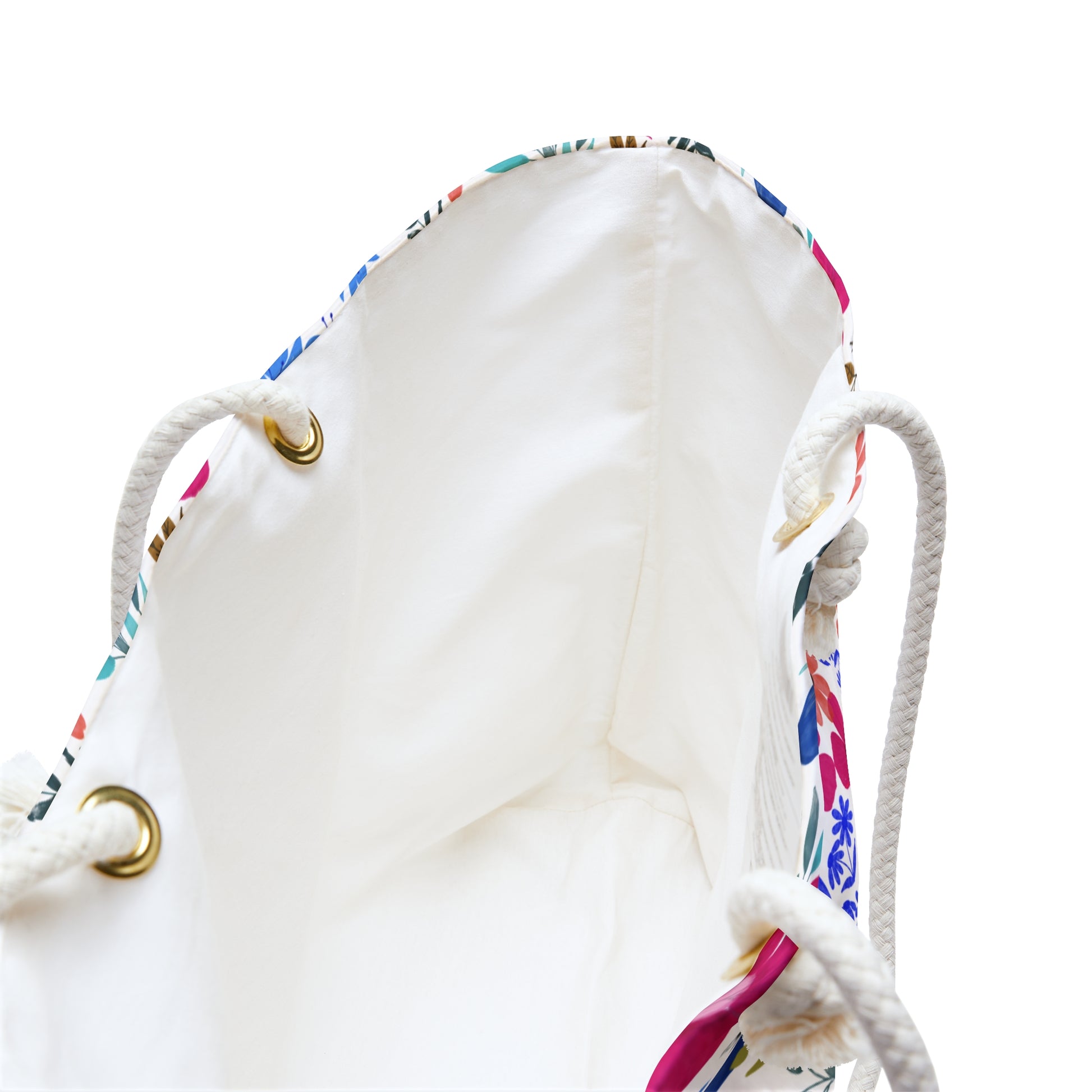 Weekender Bag interior showing unlined white fabric, braided rope handles through brass-tone grommets, and a floral print edge, embodying FireBrook Designs' stylish, uplifting approach to travel essentials.