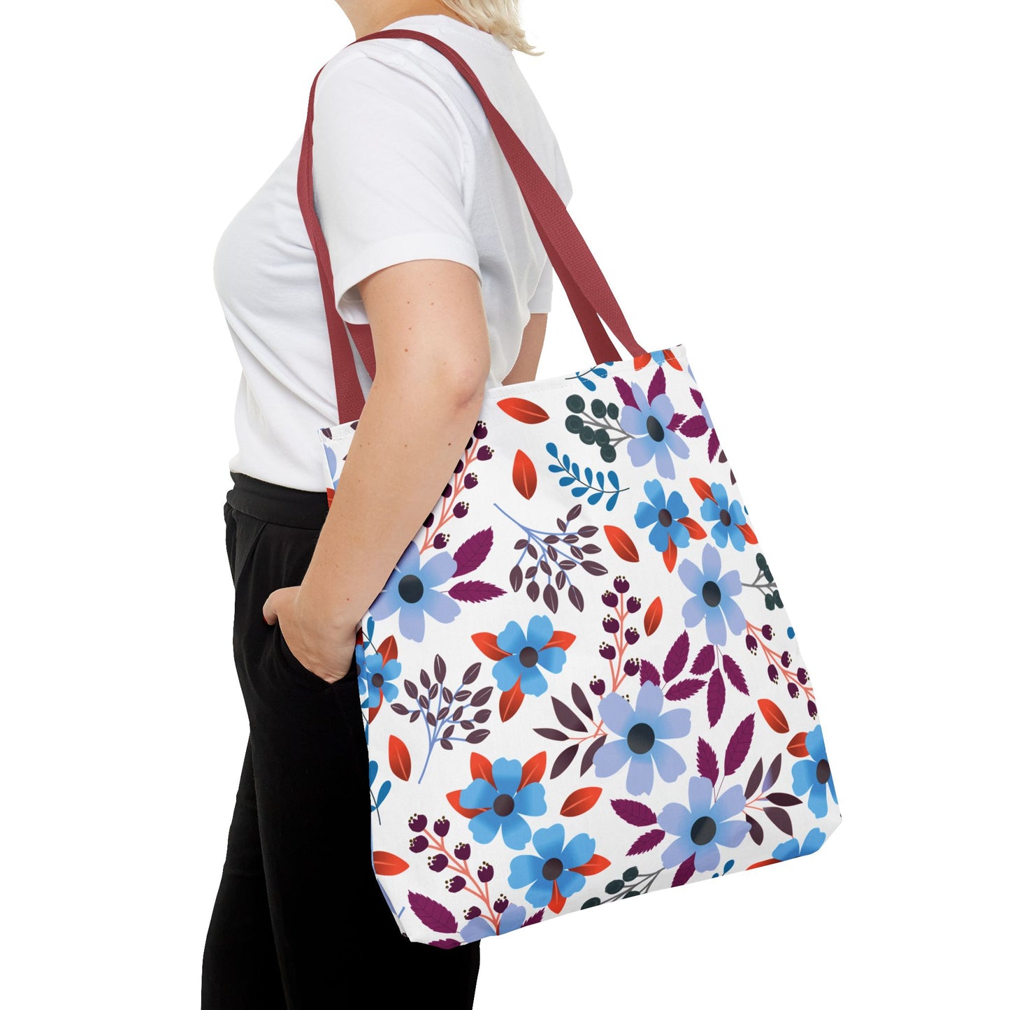 Person carrying a Floral Tote Bag with burgundy straps and a vibrant floral pattern, showcasing a cheerful design ideal for summer outings, aligning with FireBrook Designs' uplifting and stylish ethos.