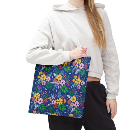 A person carries a Floral Tote Bag over their shoulder, featuring a navy-blue background with vibrant floral patterns, embodying FireBrook Designs' cheerful and practical style, perfect for summer outings.