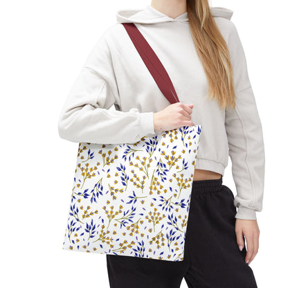A person carries the Floral Tote Bag from FireBrook Designs, featuring a white body with mustard-yellow and deep-blue botanical patterns, burgundy straps, perfect for summer outings and vibrant style.