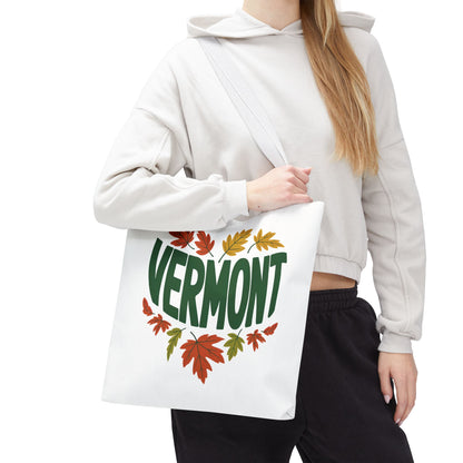 A person holds the Vermont Tote Bag, showcasing its durable design with reinforced stitching and a sleek logo, ideal for carrying essentials.