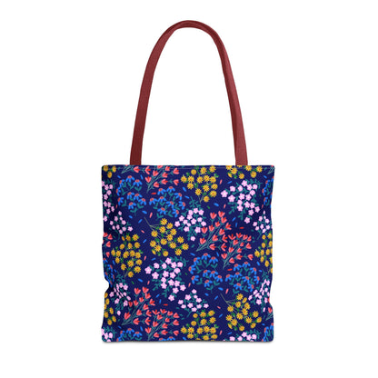 Midnight Garden Tote Bag features a navy-blue backdrop with vibrant clusters of yellow, pink, red, and blue flowers, complemented by long handles, perfect for adding stylish, cheerful functionality to daily routines.