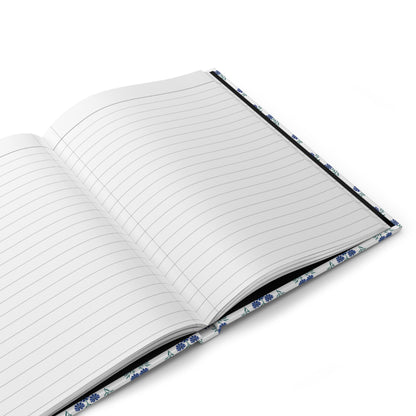HARDCOVER JOURNAL, MATTE, RULED, 5x7, SEWN BIND, CLEAN-TEAR PAGES – INDIGO DAISY: Open notebook with lined pages, sleek white and blue-flower cover, ideal for joyful, stylish note-taking.