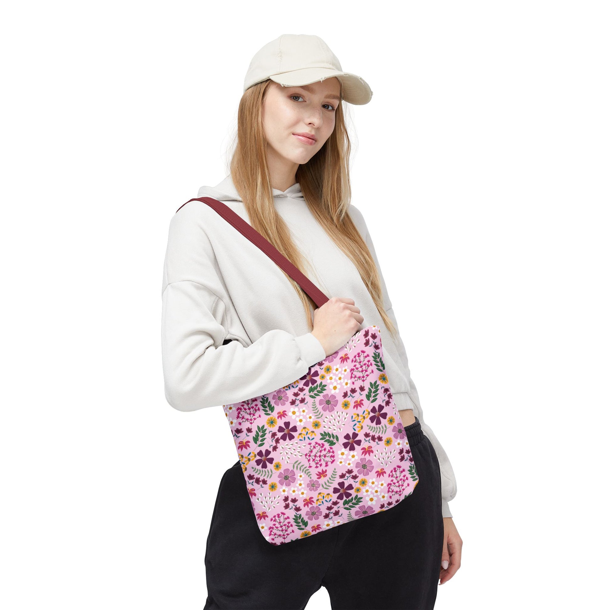 A young woman models the Floral Tote Bag, featuring a pink floral print, showcasing its stylish design ideal for everyday use. The tote complements FireBrook Essentials’ commitment to joyful, practical fashion.