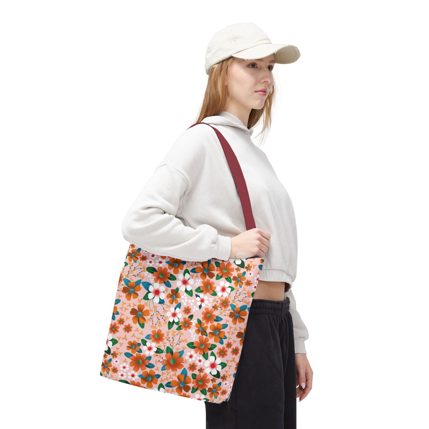 Young woman in casual attire showcasing the Peach Poppy Grove Tote Bag, featuring vibrant floral patterns. Ideal for summer outings, this durable and spacious tote embodies FireBrook Designs' cheerful and uplifting style.