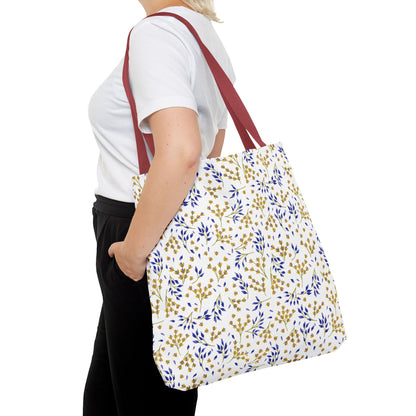 A person wears a plain white T-shirt, black pants, and carries the Wild Herb Garden Tote Bag featuring dark-red straps and a bright botanical print, perfectly embodying FireBrook Designs' uplifting and joyful style.