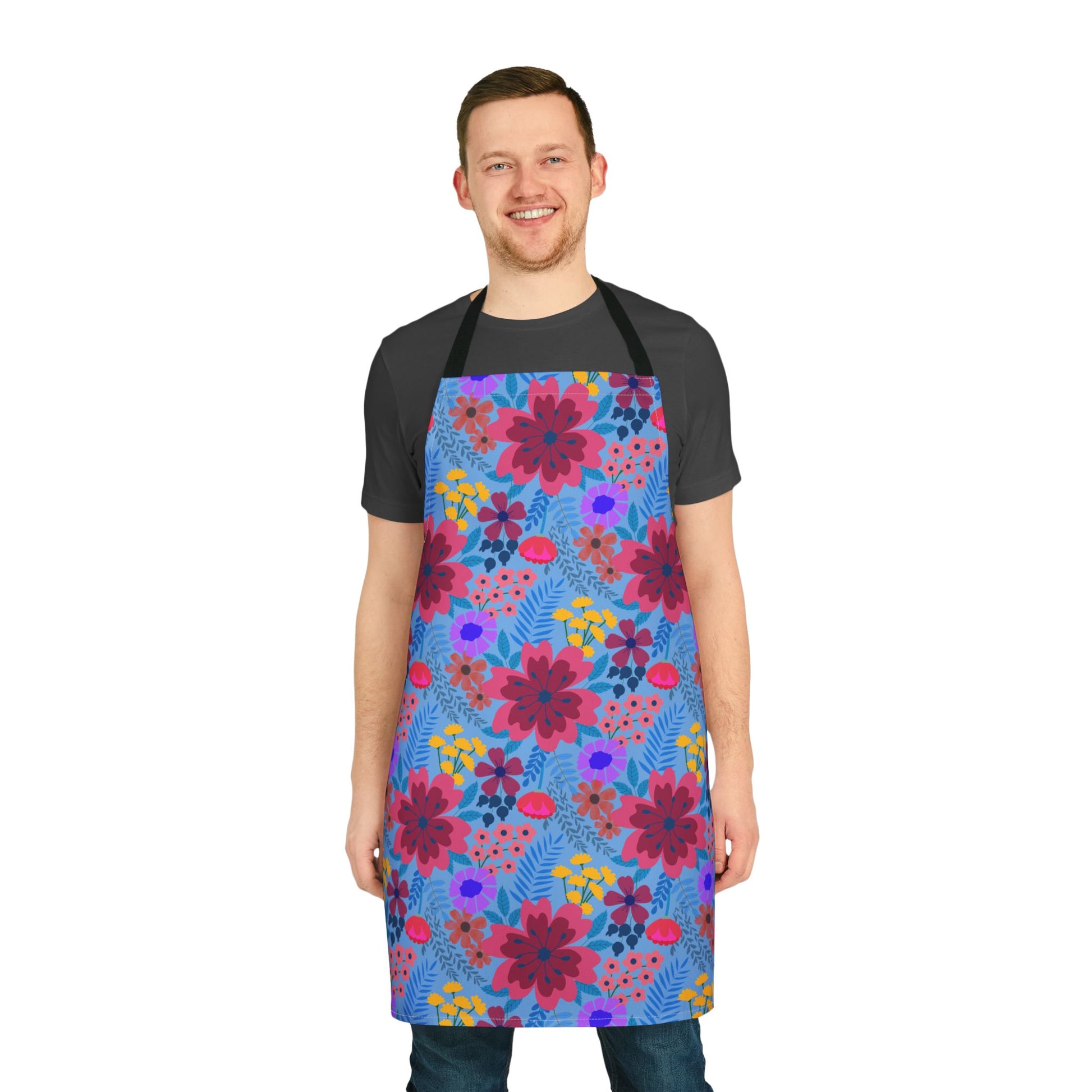 Floral Apron featuring vibrant large blossoms and blue foliage, worn by a man in casual attire. This FireBrook Essentials apron combines style and comfort, perfect for cooking or crafting activities.