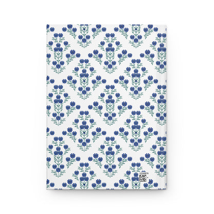 HARDCOVER JOURNAL, MATTE, RULED, 5X7, SEWN BIND, CLEAN-TEAR PAGES – INDIGO DAISY: Back cover features a pattern of small blue flowers and a discreet production barcode in the corner.