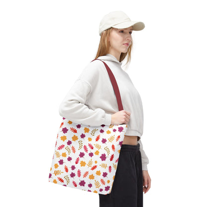 Person in casual attire showcases the Autumn Leaves Tote Bag, featuring vibrant autumn leaf patterns and burgundy straps, designed for daily use with reinforced stitching and spacious boxed corners.