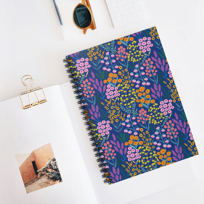 Floral Spiral Notebook with vibrant wildflower cover rests on an open magazine, accompanied by sunglasses and a notepad, embodying FireBrook Designs' joyful, stylish creativity for everyday inspiration.