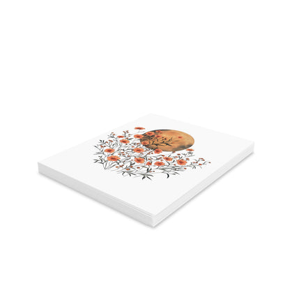 Moon Greeting Cards — Pack of 8/16/24: A stack of art cards featuring orange blossoms entwined with a watercolor moon, ideal for sending thoughtful messages. Comes with matching envelopes, perfect for joyful expressions.