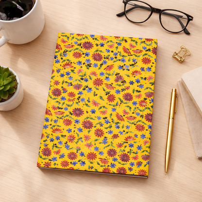 Floral Pattern Hardcover Journal — Bright Yellow Wildflower Notebook surrounded by a gold pen, black-rimmed glasses, and a succulent, showcasing FireBrook Designs' uplifting, joyful aesthetic through vibrant wildflower motifs.