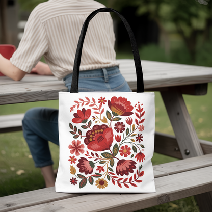 Red Floral Folk-Art Style Tote Bag with vibrant red, blush, and blue flowers, green leaves; perfect for carrying essentials. Features a durable polyester build, reinforced handles, and stylish black stitching.