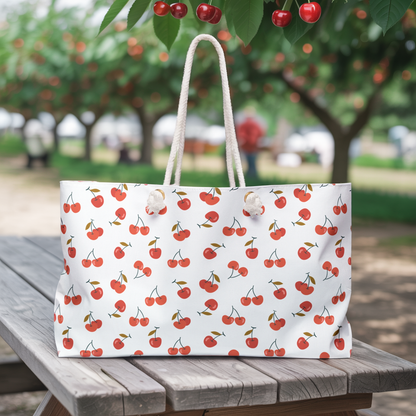 Cherry Weekender Bag featuring a playful cherry pattern, spacious design with chic cream-colored rope handles, ideal for weekend getaways, embodying FireBrook Essentials' commitment to uplifting, joyful designs.